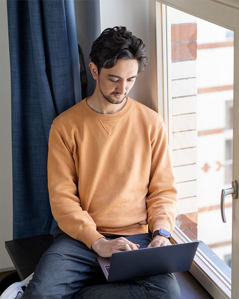 Male employee on a laptop by the window